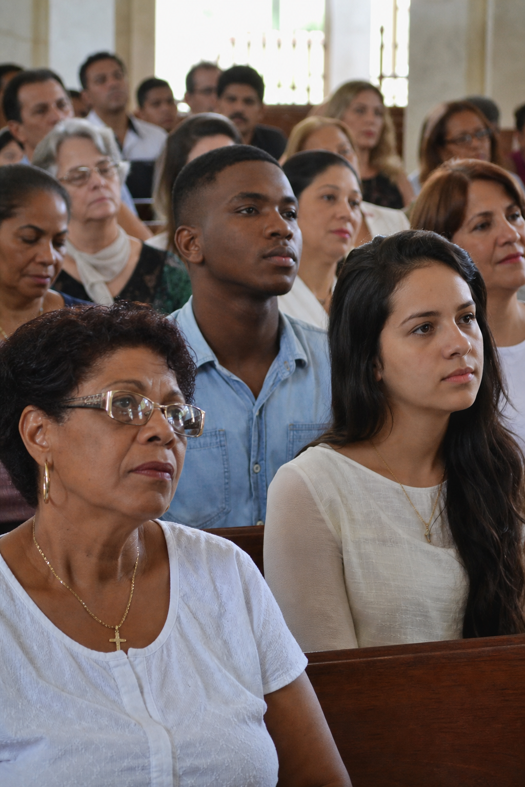 Diverse congregation listening attentively in natural daylight